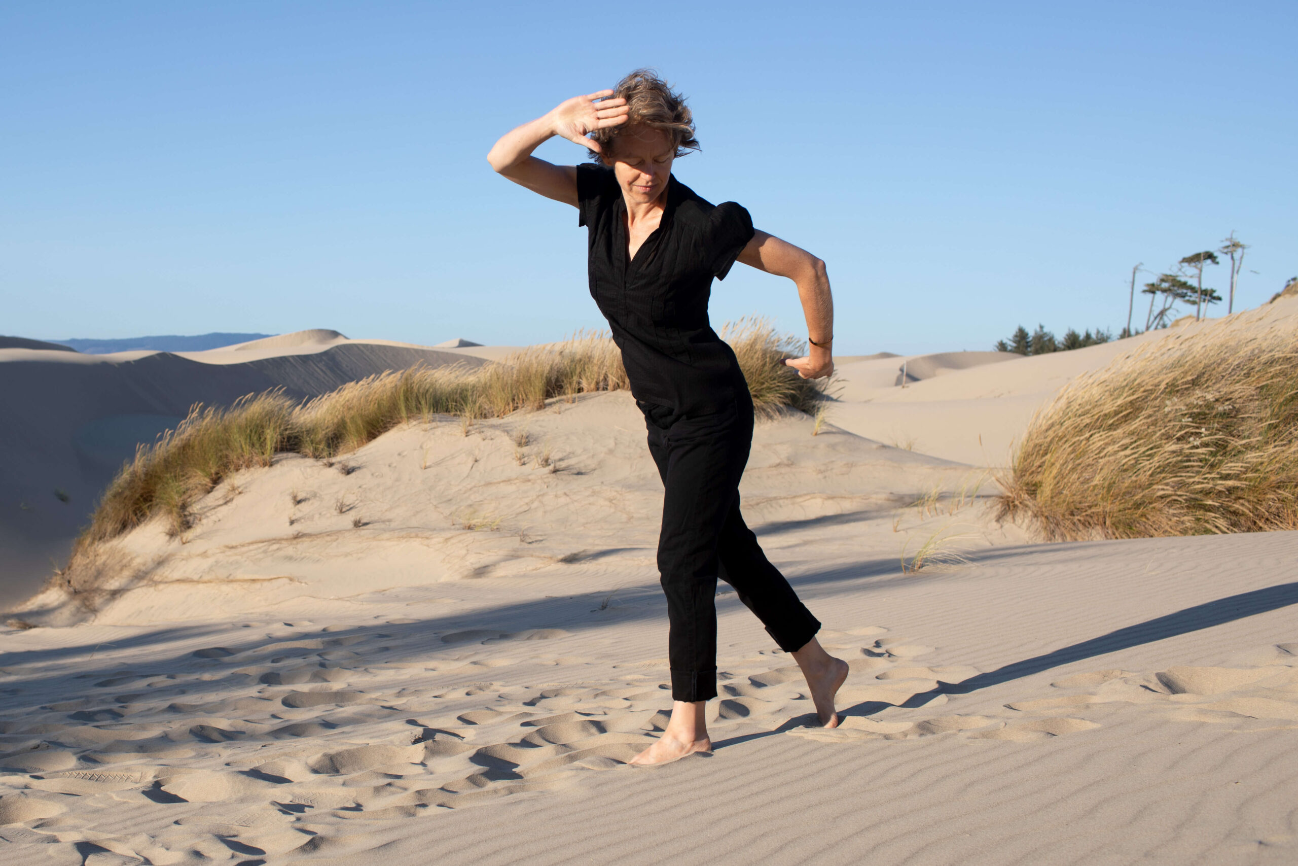 Qi Gong practice on the Oregon dunes under a blue sky.